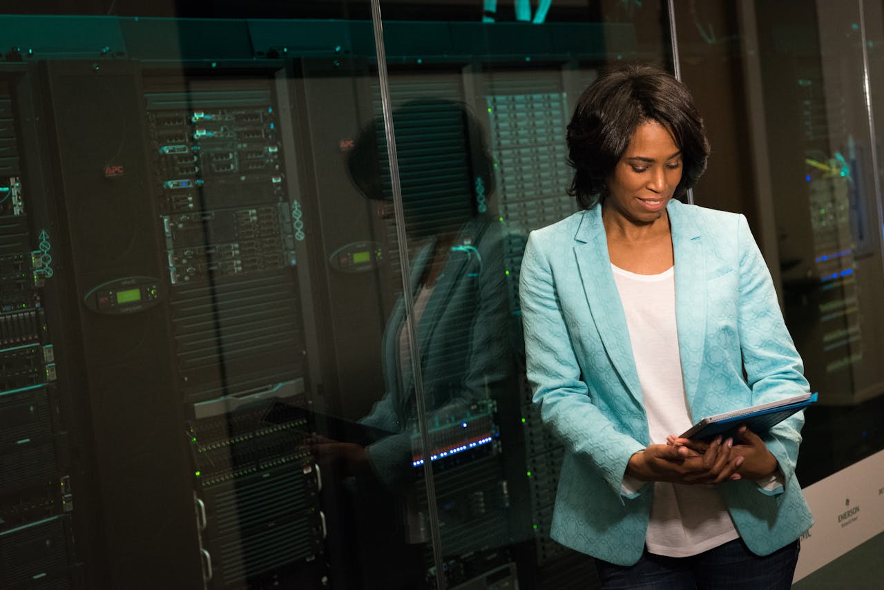why-choose-us Female IT professional examining data servers in a modern data center setting.